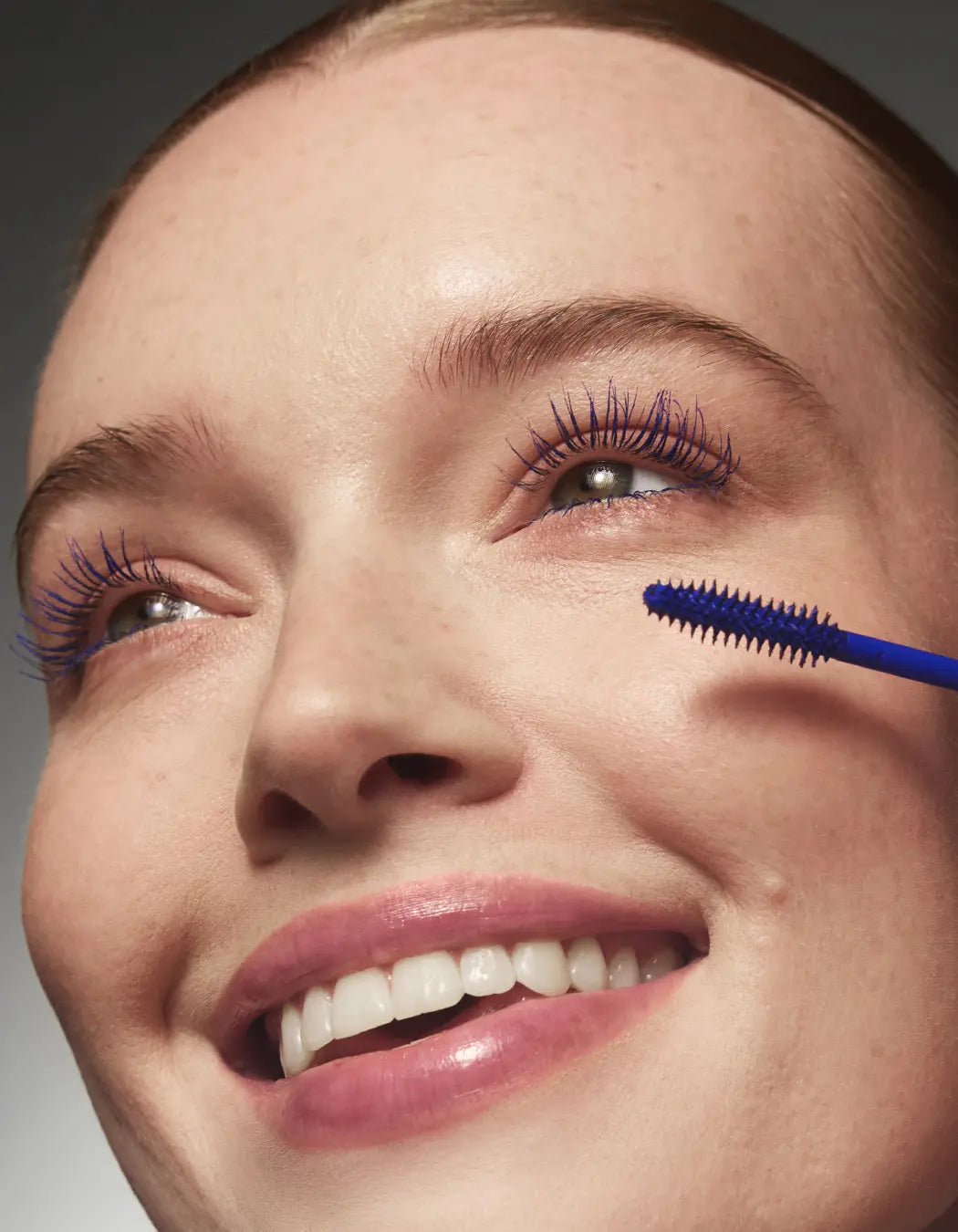 Model applying indigo-blue lash primer